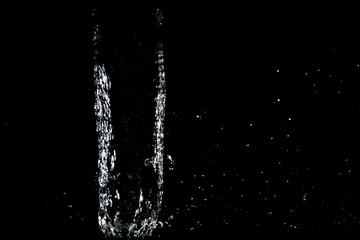 Obraz na płótnie Canvas water splash drop to the ground on Black background . Close up of splash of water forming explode shape