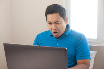 Man Shocked with Open Mouth to See Bad News on Internet