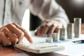 Businessman accountant Calculating on data documents And pile Stack Of coins, the savings money investment. financial Budget planning concept