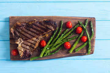 Grilled T-bone steak with asparagus and cherry tomatoes