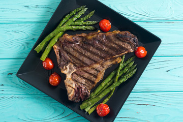 Grilled T-bone steak with asparagus and cherry tomatoes