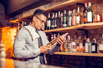 Businessman standing and reading description of wine