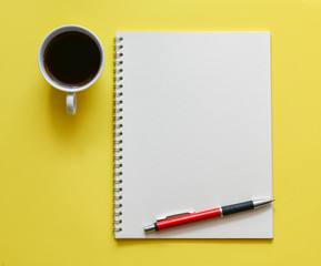 Top view, empty notebook on a yellow background