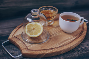 Green tea in white cup, lemon under transparent lid