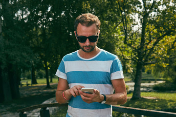 Fototapeta premium Trendy man using cellphone outdoors.