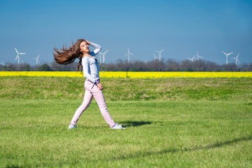 A young girl jumping on the grass, a girl in the nature of sports.Girl on the nature does acrobatic...