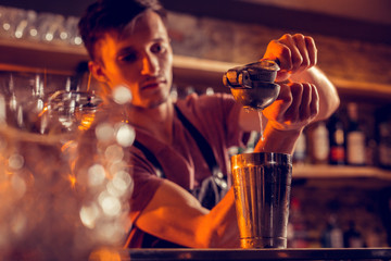 Close up of barman squeezing some lemon juice into shaker