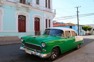 Old-timer car in front of colonial house in Cienfuegos, Cuba