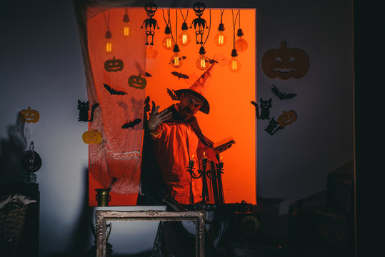 Happy hipster with bloody beard with pumpkins. Wizard, sorcerer, warlock. Mystery and horror concept. Jack o lantern.