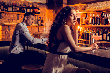 Man looking at beautiful curly woman in the bar