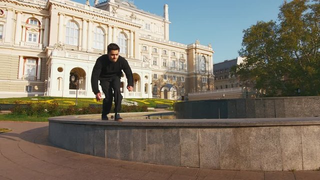 Parkour athlete doing frontflip from in old city center during sunrise, slow motion