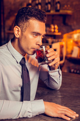 Successful man relaxing while drinking whisky in bar