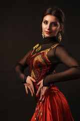 Beautiful belly dancer perfoming exotic dance in red flutter dress