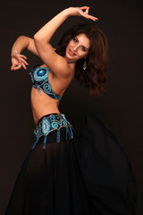 Beautiful belly dancer perfoming exotic dance in red flutter dress