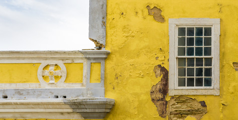 Window and aged, rustic yellow wall of old traditional building in Algarve, Portugal