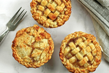 savory meat american english mini pie with vintage rustic fork Traditional rustic homemade savory meat apple cherry pie on white plate with vintage rustic fork with fork