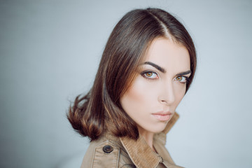 Attractive girl with perfect skin. Makeup, smooth skin. Beauty woman in studio on gray background....