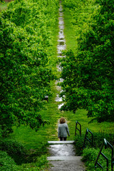 Dover Stone Church, New York, USA A woman walking along a tree-lined alley after the rain.