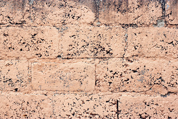 Brick wall fragment. Old dirty orange and red bricks with defects. Grunge texture with cracks and weathered