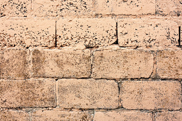 Brick wall fragment. Old dirty orange and red bricks with defects. Grunge texture with cracks and weathered