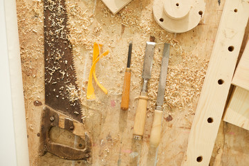 Above view background of carpenters tools on table in workshop dusted with wood shavings, copy space