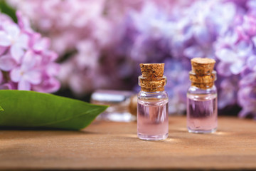 spa aromatherapy - essential oil bottles and lilac flowers