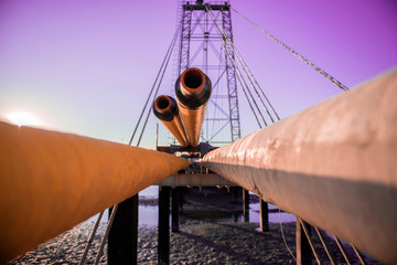 Oilfield pipeline bridge in sunset background