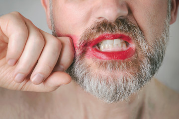 Bearded angry man with Red Lipstick on his lips