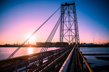 Oilfield pipeline bridge in sunset background