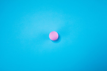 Pink ball lie on pastel blue background. Minimal summer concept.