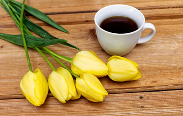 Styled stock photo. Spring feminine scene, floral composition. Bunch of beautiful tulips and coffee on the wooden table.Top view.