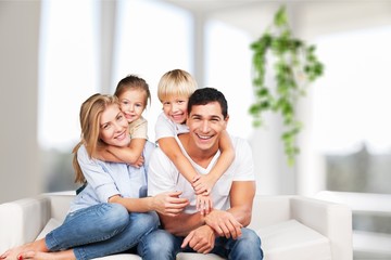 Obraz premium Beautiful smiling family sitting at sofa at home