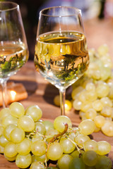 glass of White wine ripe grapes and bread on table in vineyard