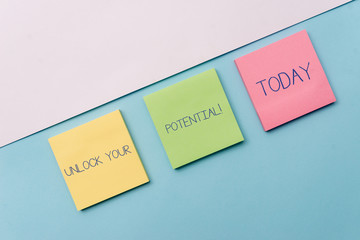 Text sign showing Unlock Your Potential. Business photo showcasing release possibilities Education and good training is key Pastel colour note papers placed sideways on the of softhued backdrop