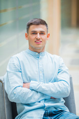 handsome young man in blue shirt indoors