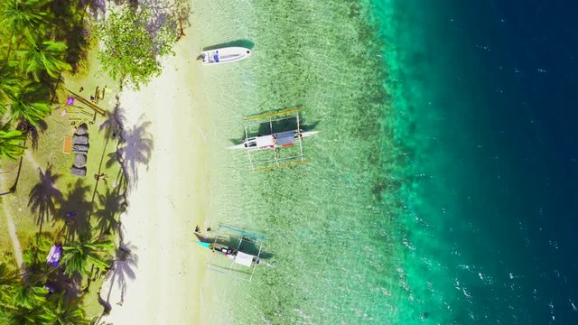 Boats Moored at paradise tropical Ipil Beach on Pinagbuyutan Island with azure turquoise sea in El Nido, Palawan, Philippines