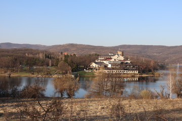 Beach in front of artificial lake, hotel in the distance in autumn weather