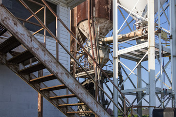 Geometric shapes formed by various metal arms and stairs at an abandoned concrete plant