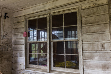 Fototapeta na wymiar Windows on the exterior of an old abandoned farm house