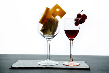 Composition of glasses with ripe grape and red wine served on slate board