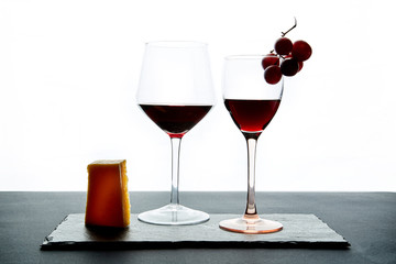Composition of glasses with ripe grape and red wine served on slate board