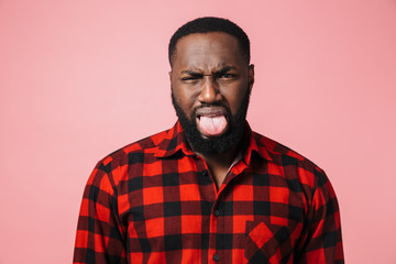 Fototapeta premium Portrait of a disgusted african man wearing plaid shirt