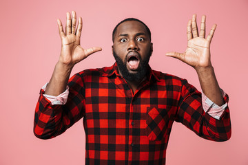 Fototapeta premium Portrait of a shocked african man wearing plaid shirt