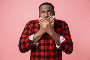 Portrait of a shocked african man wearing plaid shirt