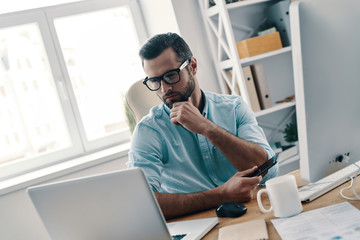 On the way to success. Young modern businessman working using computer while sitting in the office