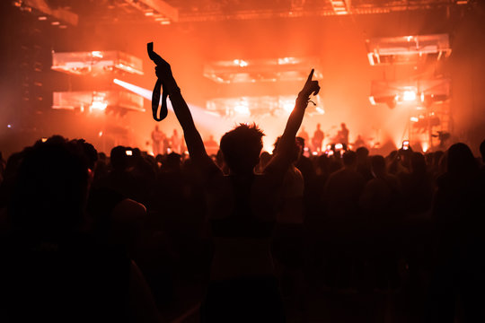 people at a concert with their hands in the air dancing and singing 