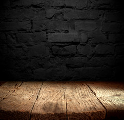 Old wooden table with brick background dark