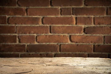 Old wooden table with brick background dark