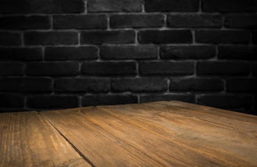 Old wooden table with brick background dark