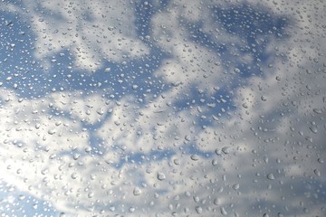 Raindrops on the window glass.The sun illuminates the outgoing clouds,weather change.